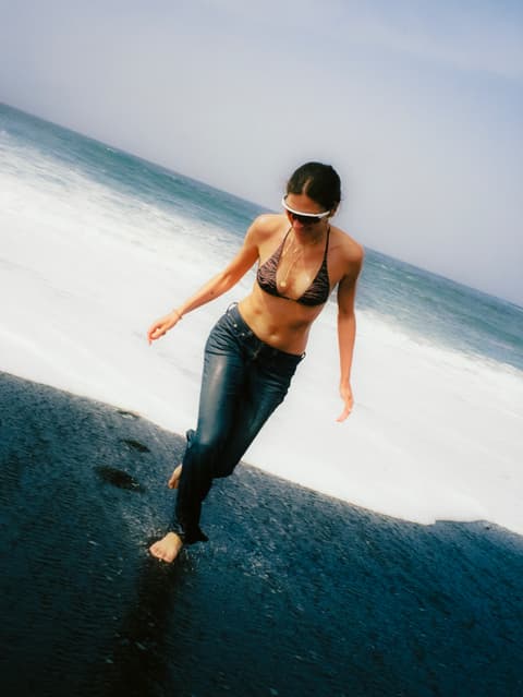 Fotografia de model a la platja, amb estil creatiu de productora audiovisual i film director