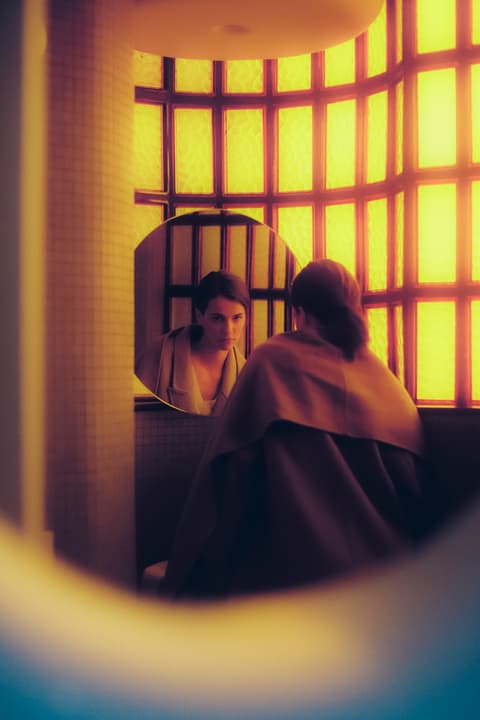 Foto artística de dona mirant-se en mirall, producció audiovisual Barcelona amb estil filmmaker